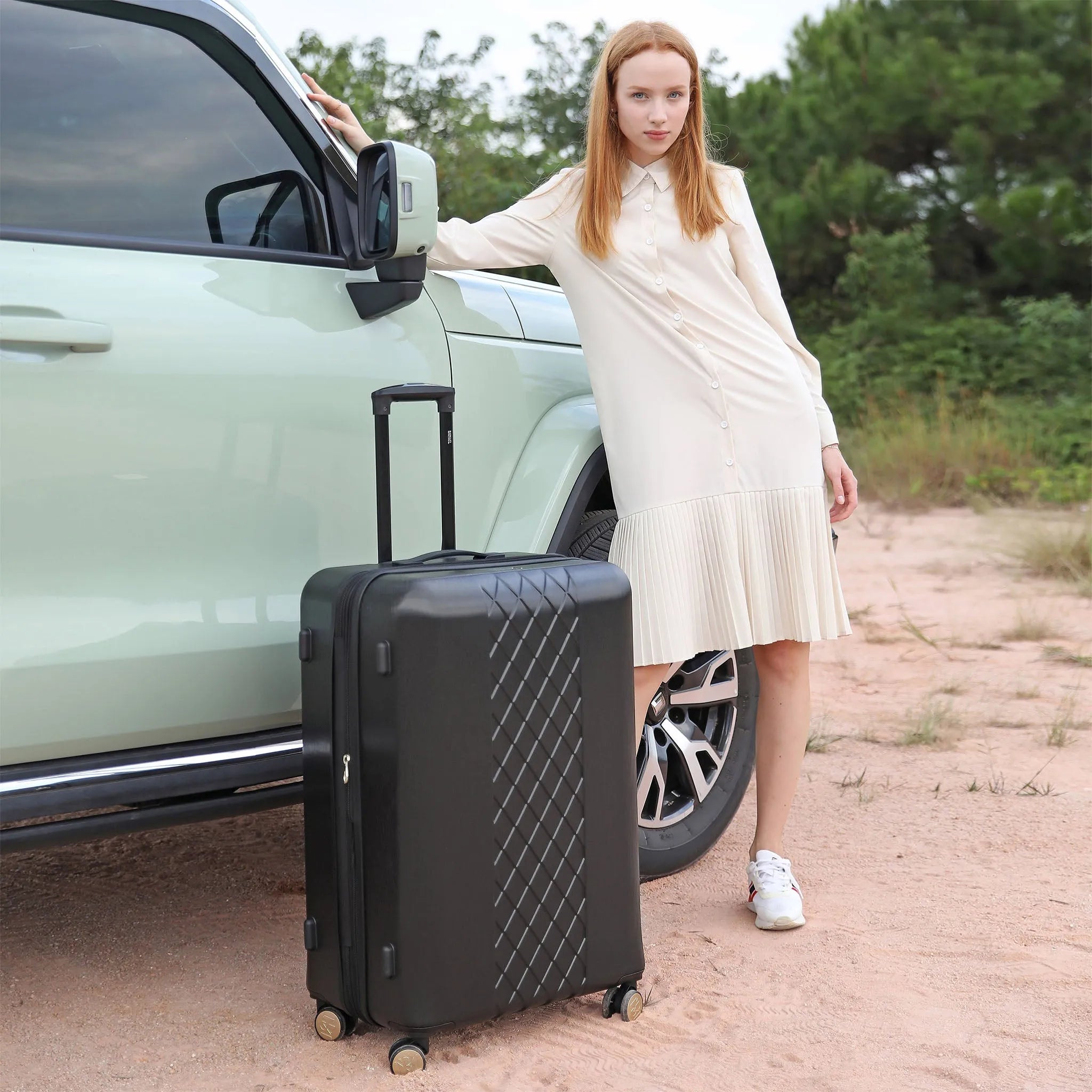Woman standing next to a car with a suitcase on a dirt road