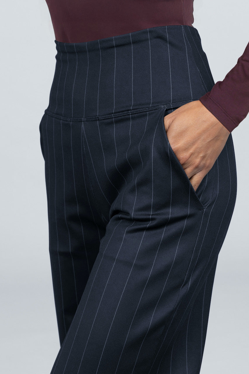 Navy pinstripe pants worn by a person on a light gray background