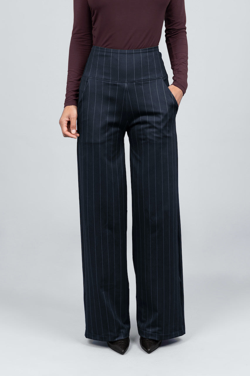 Person wearing dark pinstripe pants on a light gray background
