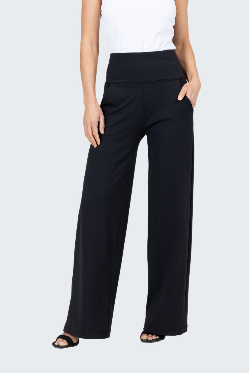 Person wearing black wide-leg pants on a gray background