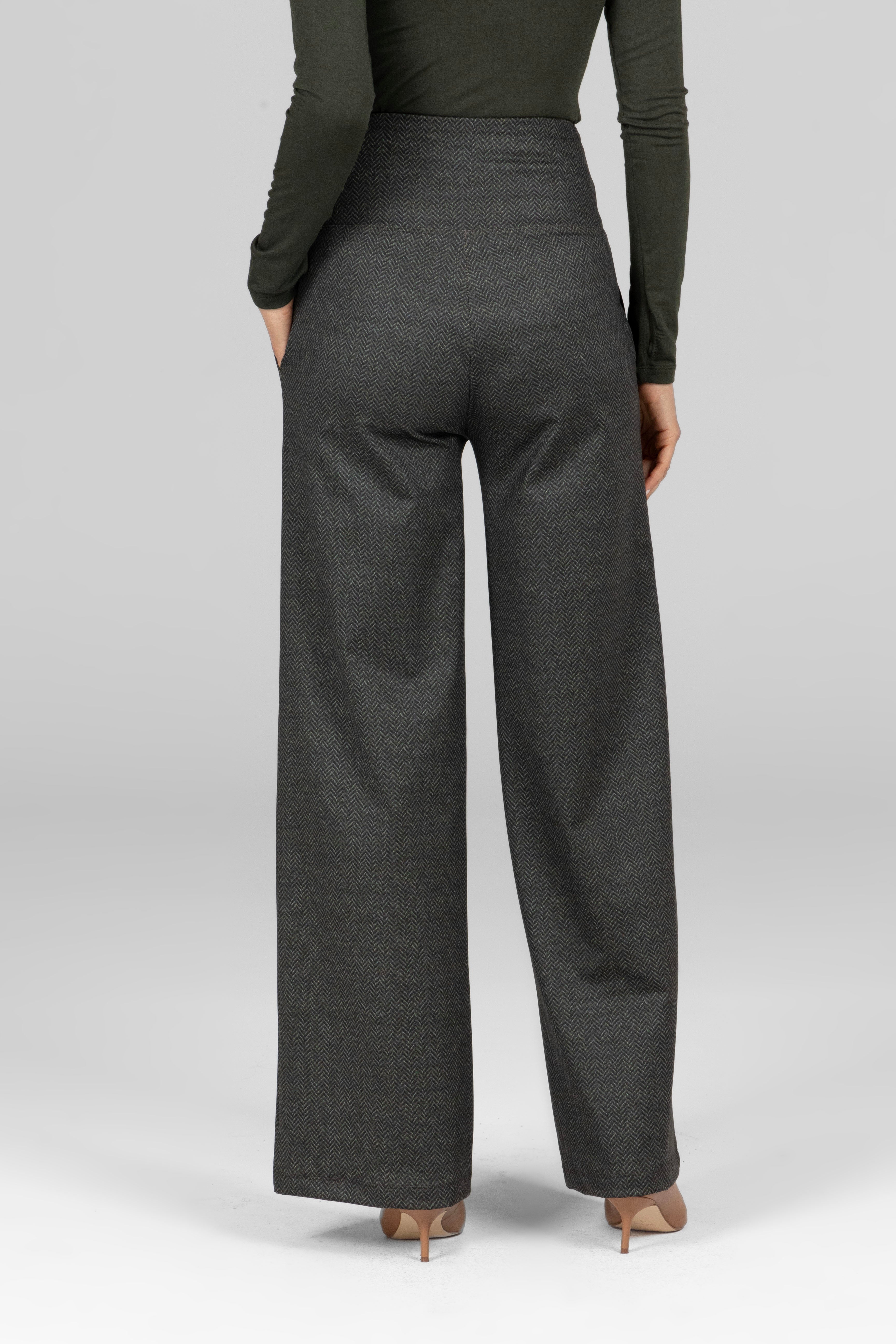Person wearing dark gray wide-leg pants on a light gray background