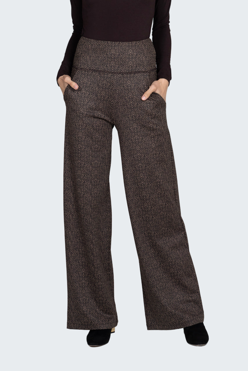Brown patterned pants worn by a person on a gray background