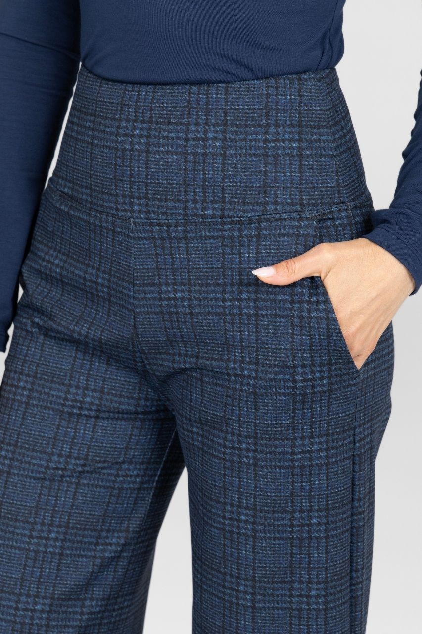 Blue checkered pants worn by a person on a white background