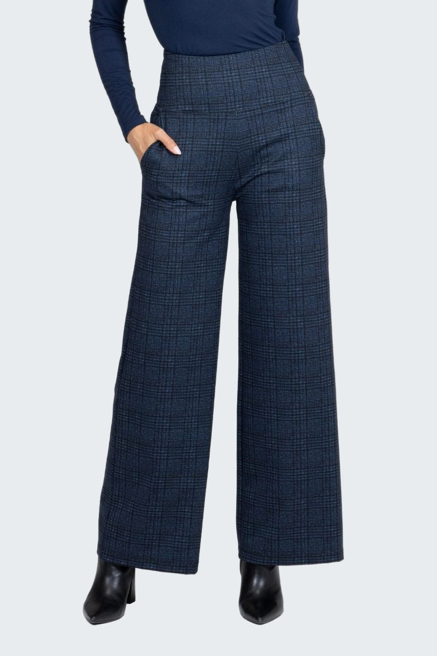 Navy checkered pants worn with a navy top on a white background
