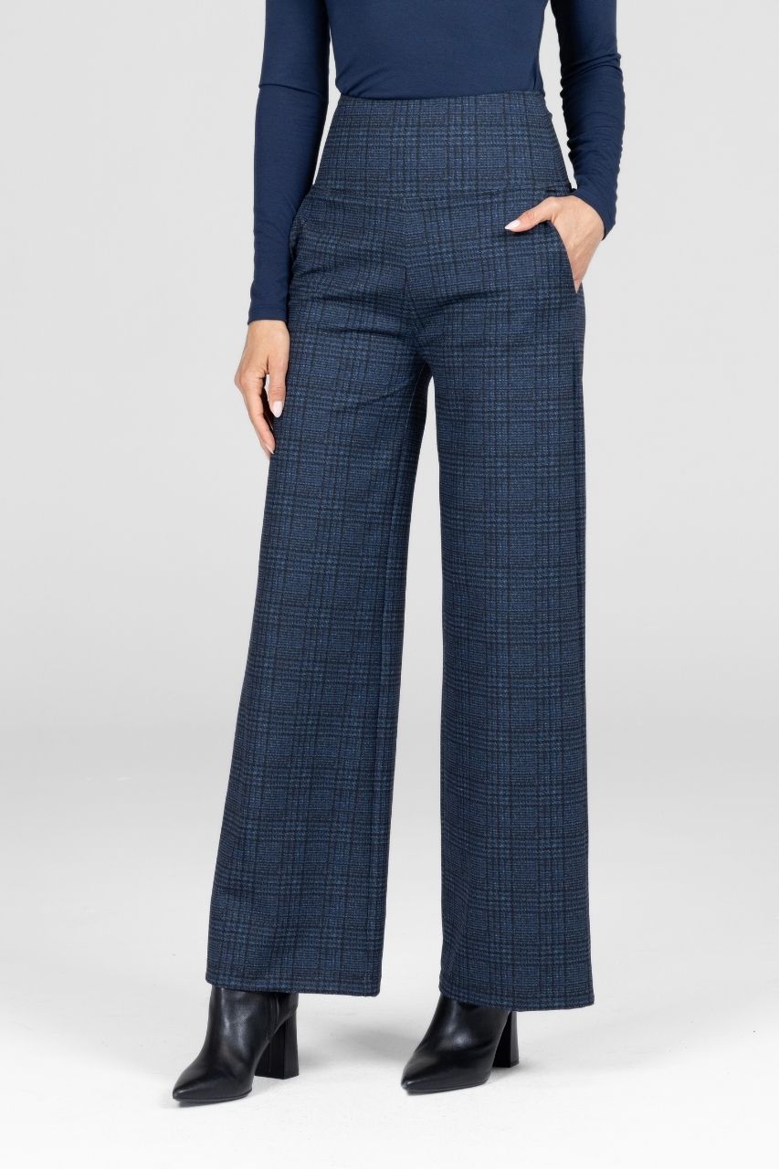 Person wearing blue checkered pants with a white background