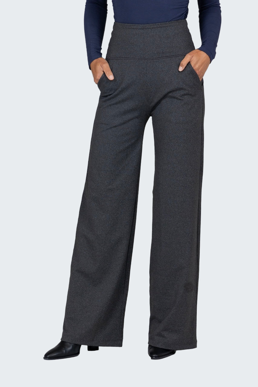 Person wearing dark gray wide-leg pants with a plain background