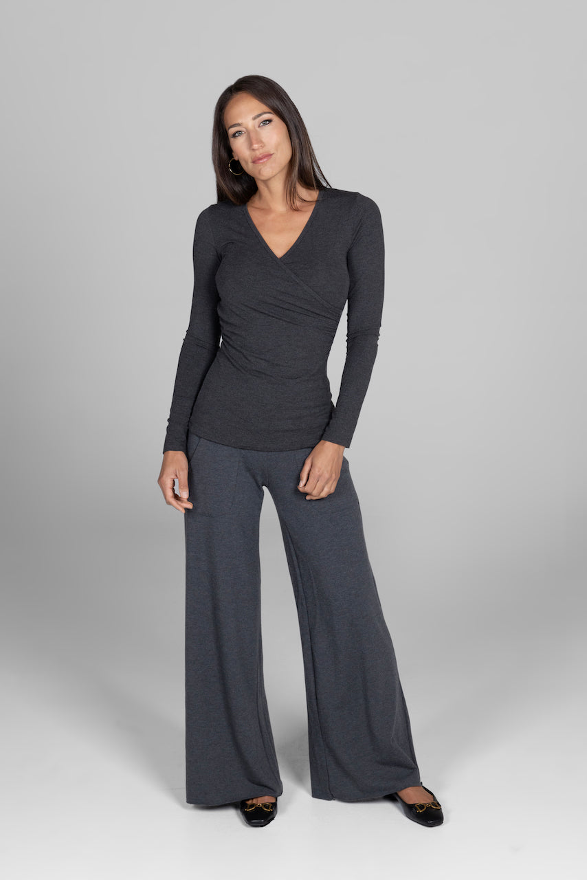 Woman wearing a gray long-sleeve top and wide-leg pants on a gray background