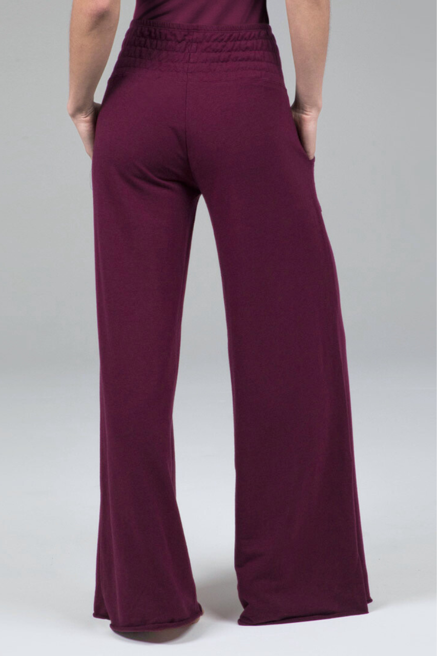 Maroon pants worn by a person on a white background