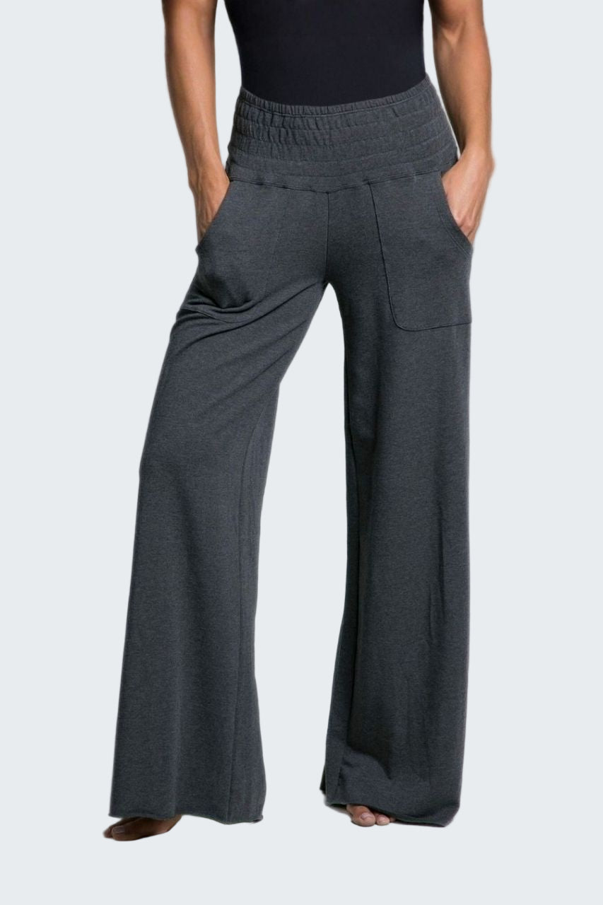 Person wearing dark gray wide-leg pants on a plain background