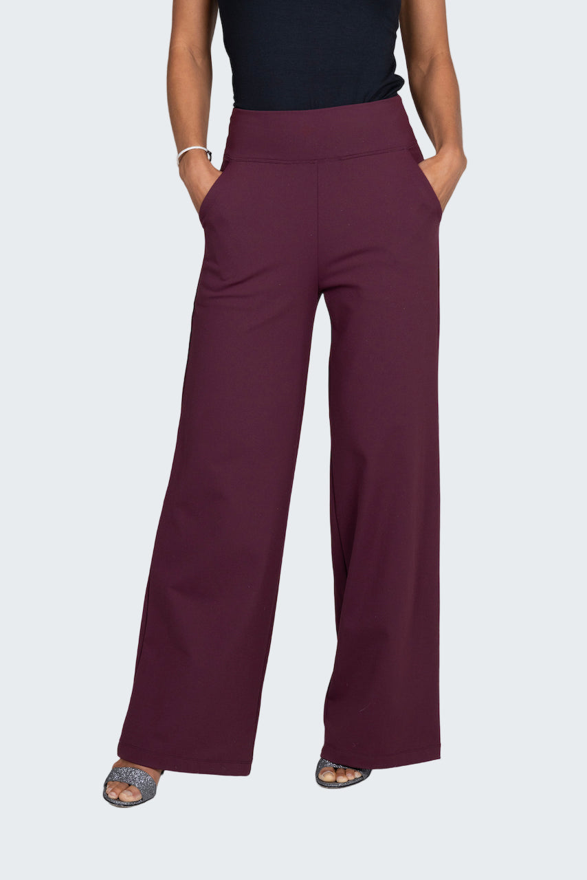 Person wearing maroon wide-leg pants on a plain background