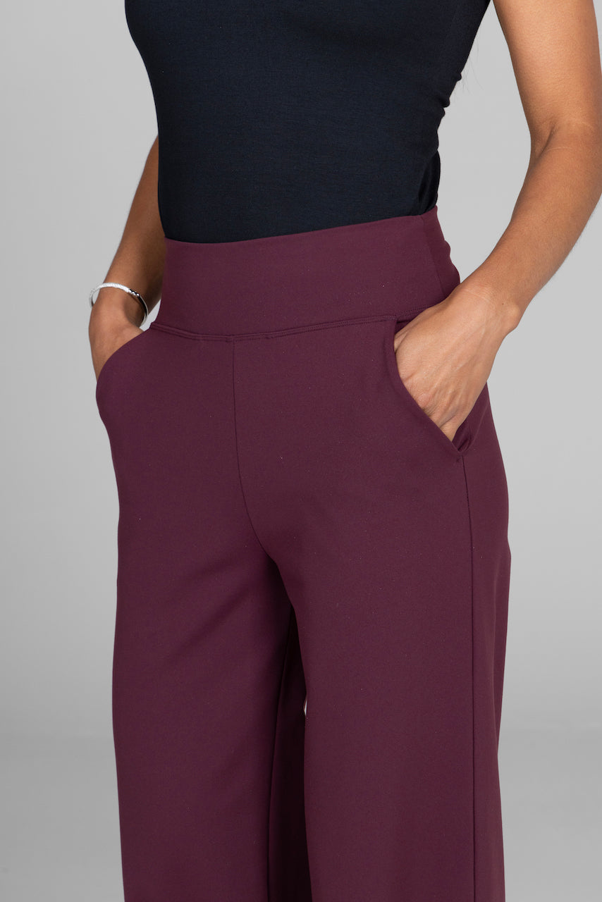 Purple pants worn by a person on a gray background