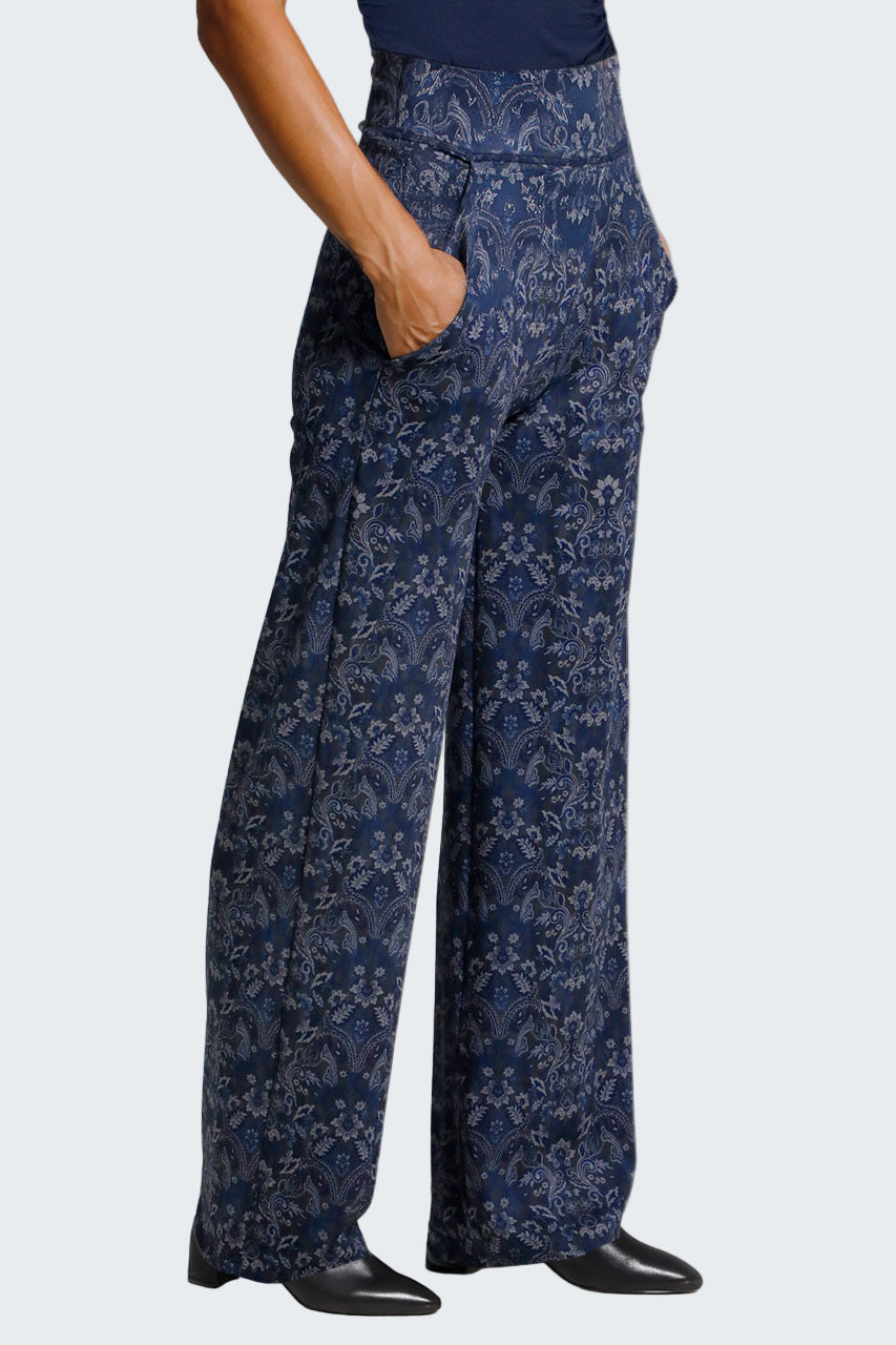 Navy floral-patterned pants worn by a person on a light gray background