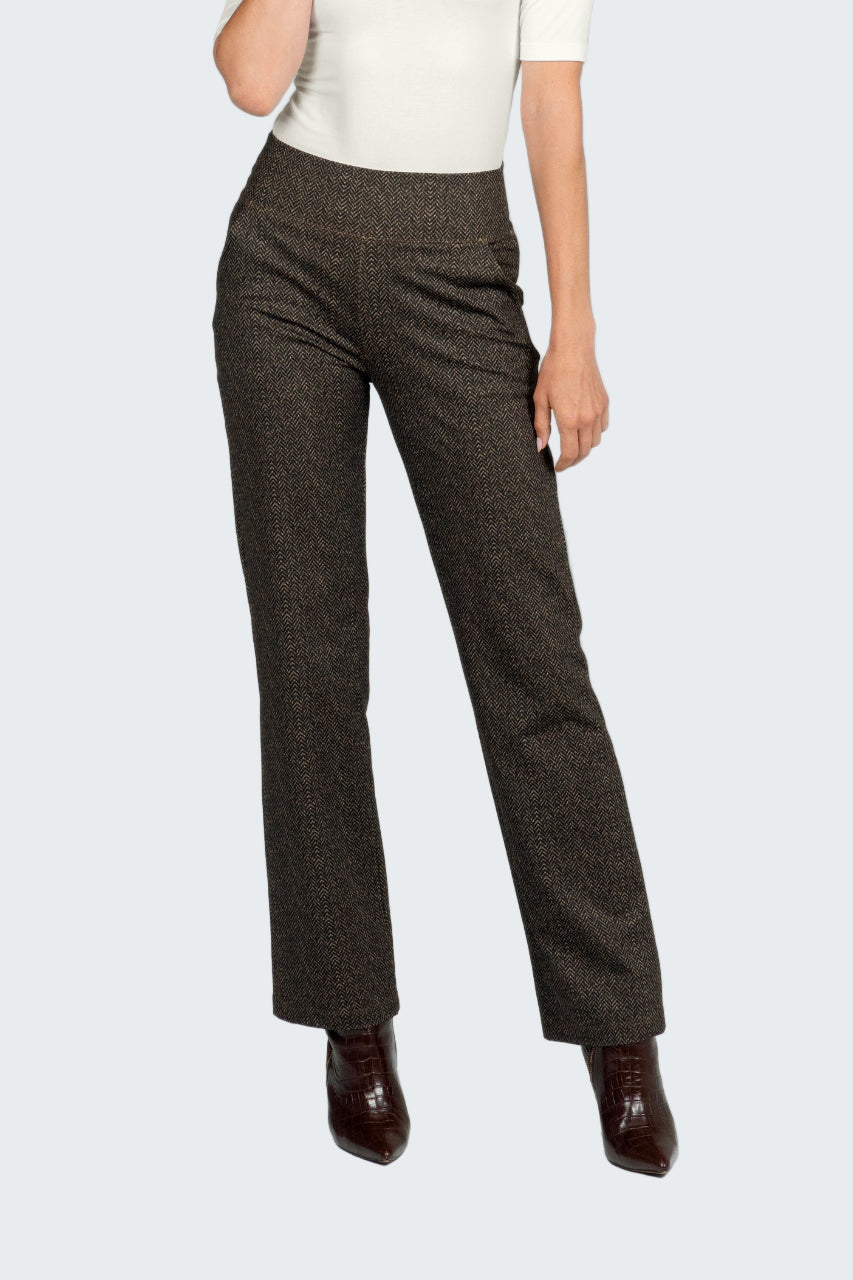 Brown herringbone pants worn by a person on a white background