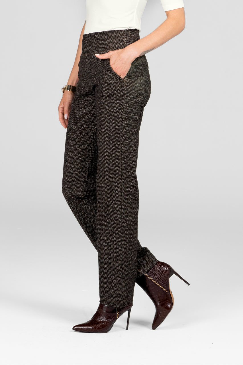 Dark patterned pants worn by a person on a white background