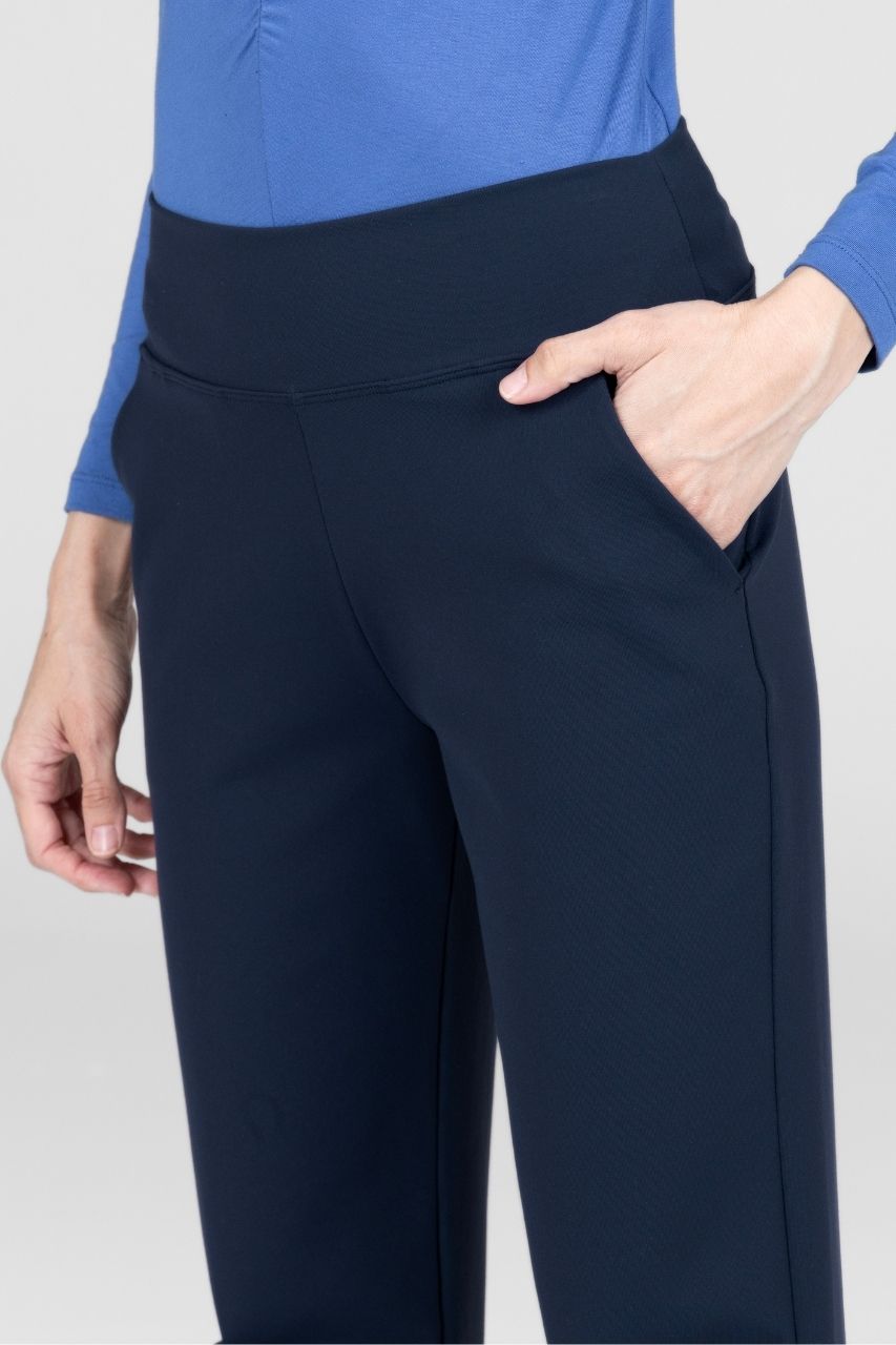Navy pants worn with a blue top on a light gray background