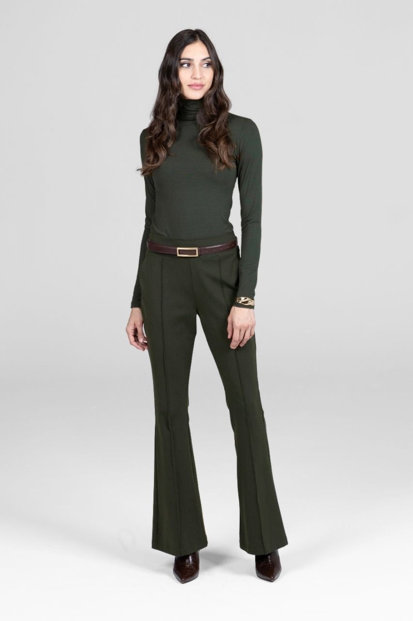 Woman wearing a green outfit with a belt on a white background