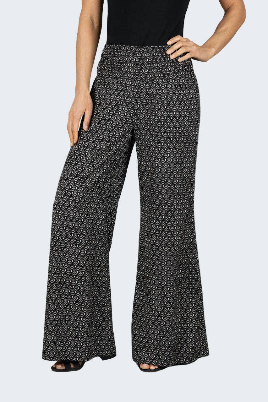 Black patterned pants worn by a person on a gray background