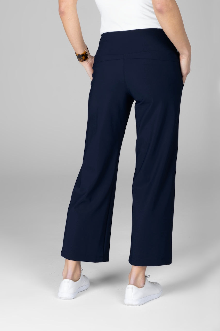 Navy blue pants worn by a person on a gray background