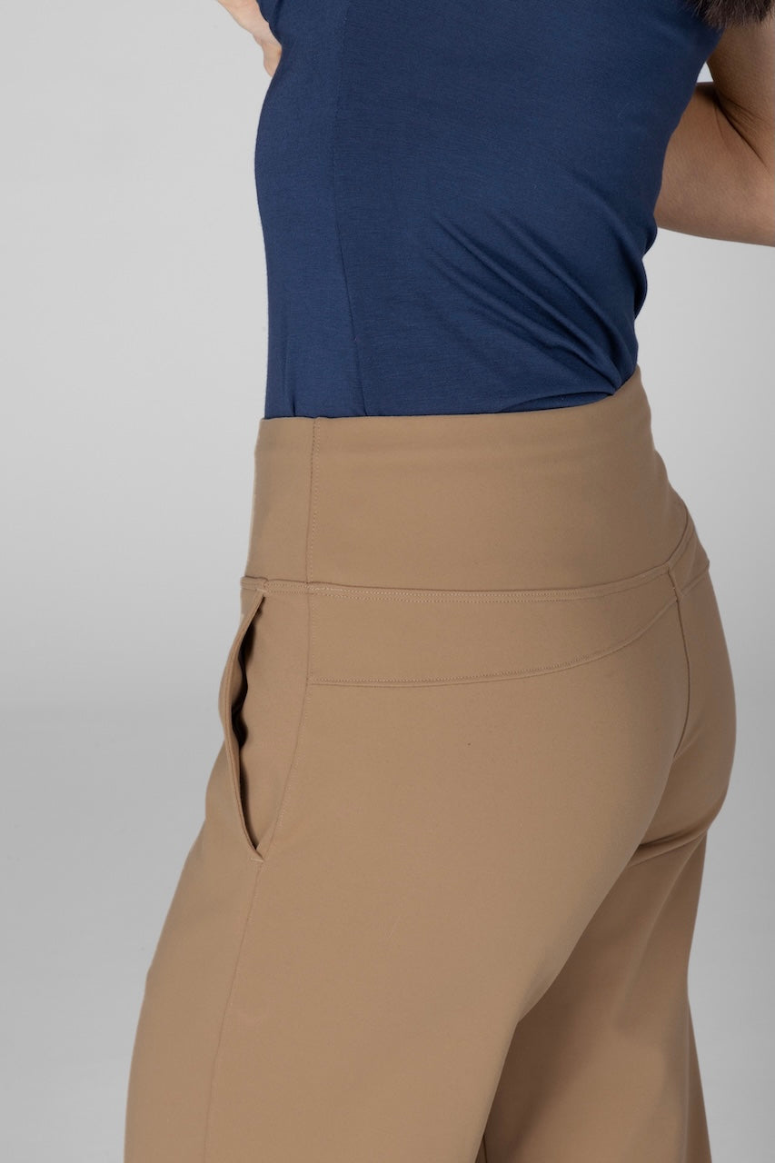 Person wearing a blue top and tan pants on a plain background