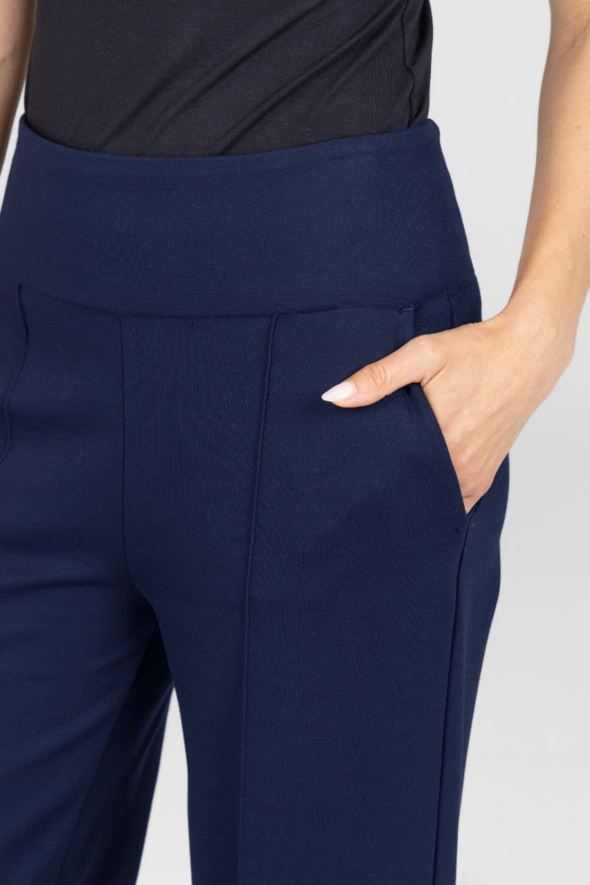 Navy blue pants worn by a person on a light gray background