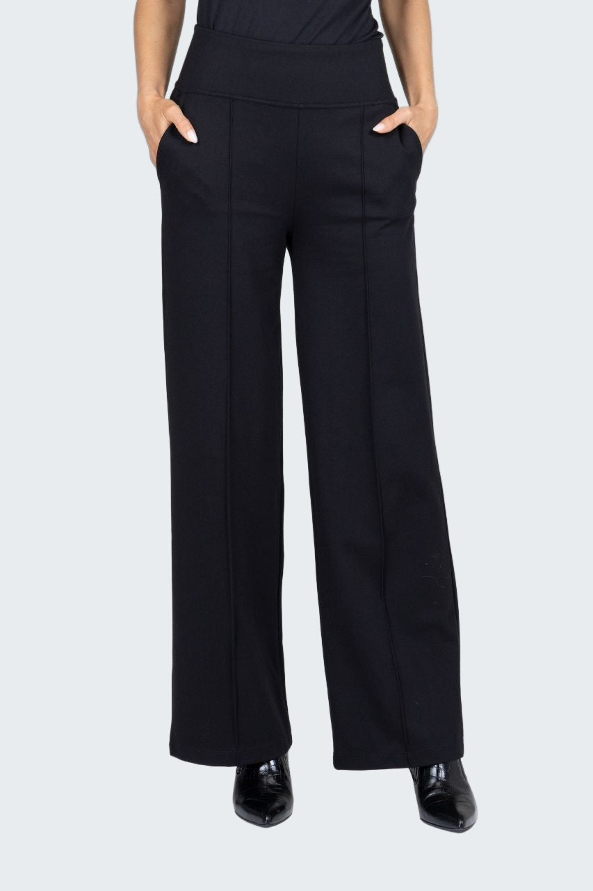 Person wearing black high-waisted pants on a white background