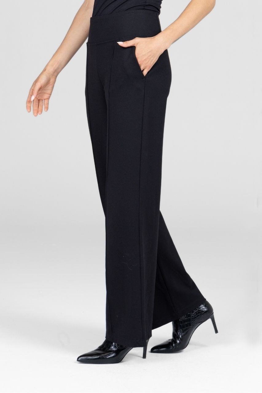 Person wearing black wide-leg pants on a white background