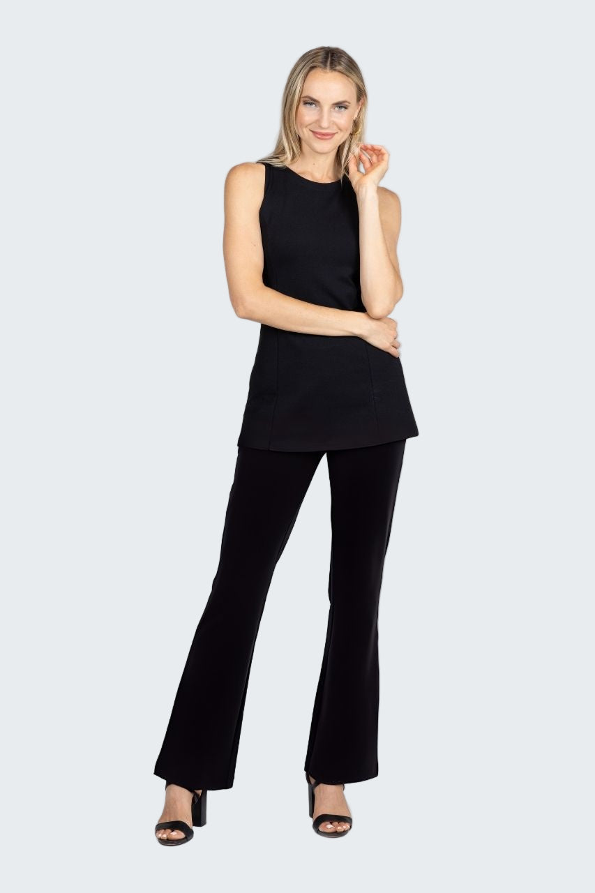 Woman wearing a black sleeveless top and black flared pants on a white background