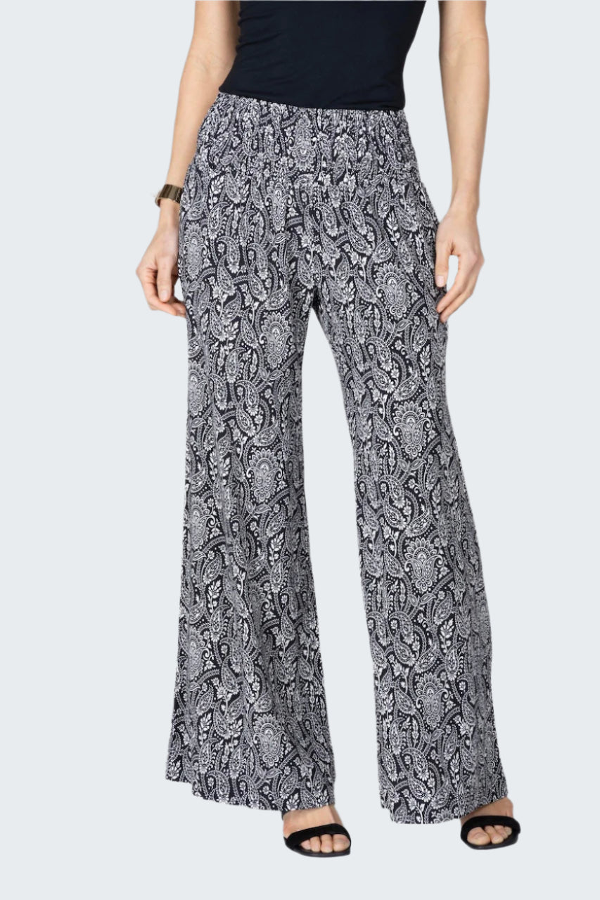 Person wearing a black and white patterned pants on a white background