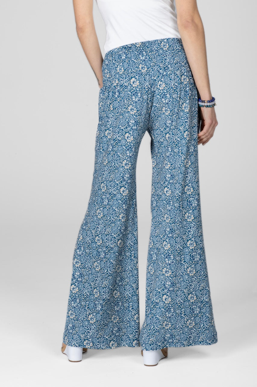 Blue floral-patterned pants worn by a person on a white background