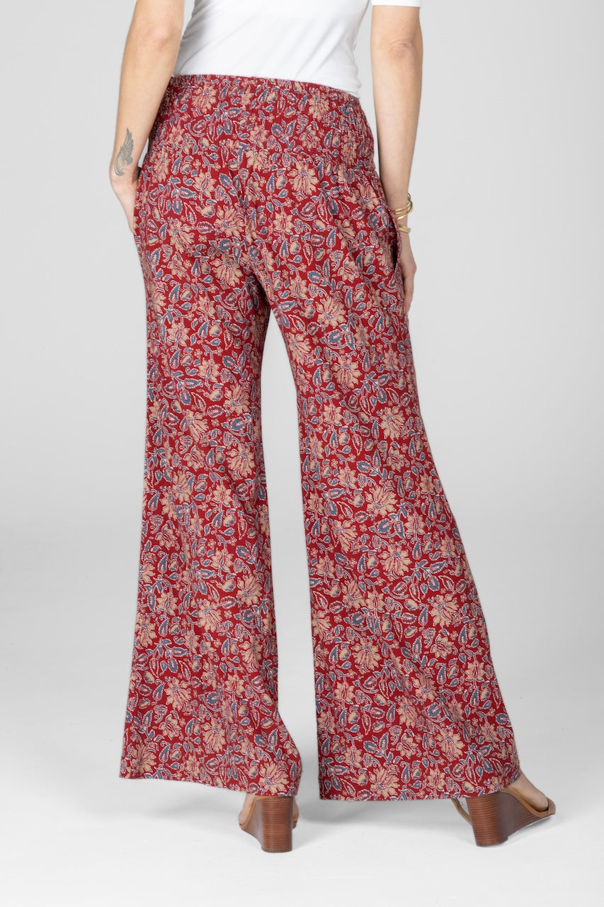 Red floral-patterned pants worn by a person on a white background