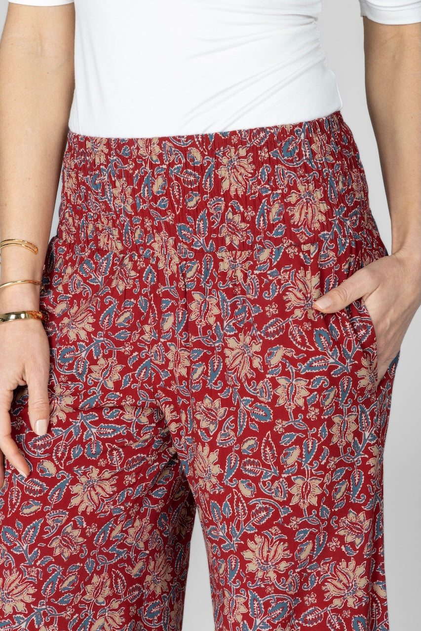 Red patterned pants worn by a person on a plain background