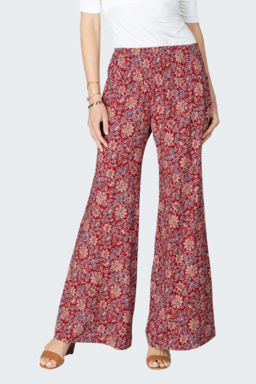 Woman wearing red floral patterned pants on a white background