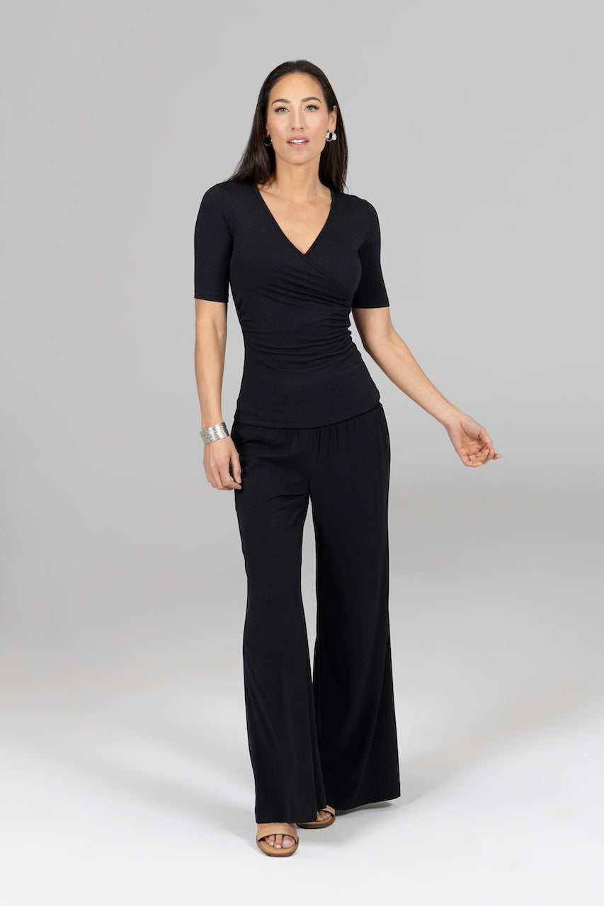 Woman wearing a black jumpsuit on a gray background