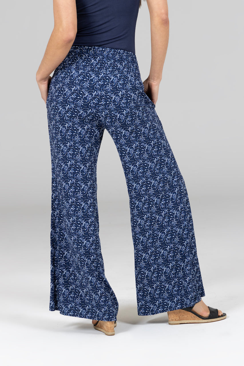 Navy blue floral-patterned pants worn by a person on a light gray background