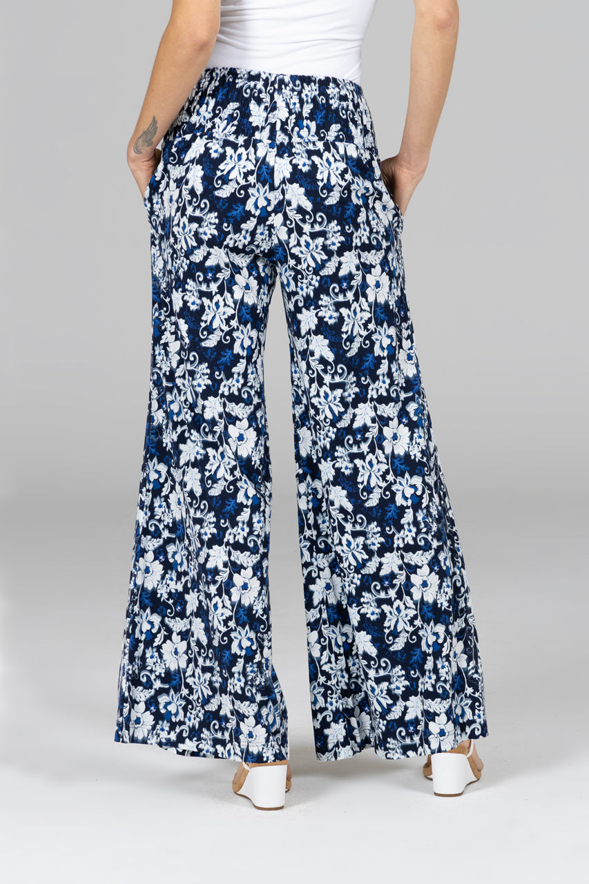 Navy floral wide-leg pants worn by a person on a gray background