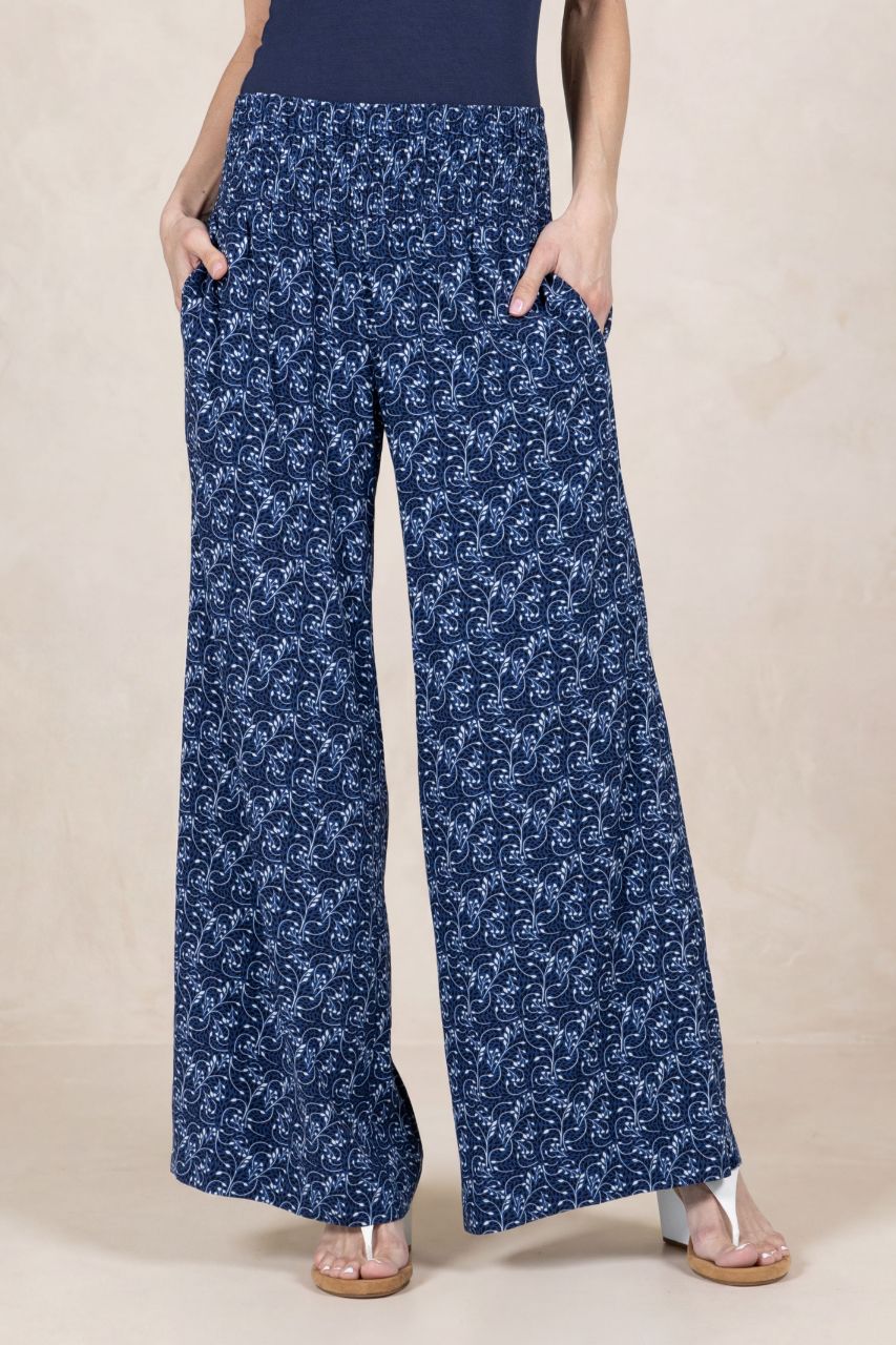 Person wearing blue floral wide-leg pants on a beige background