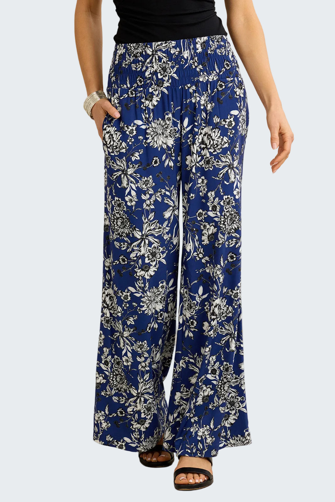 Blue floral-patterned pants worn by a person on a beige background
