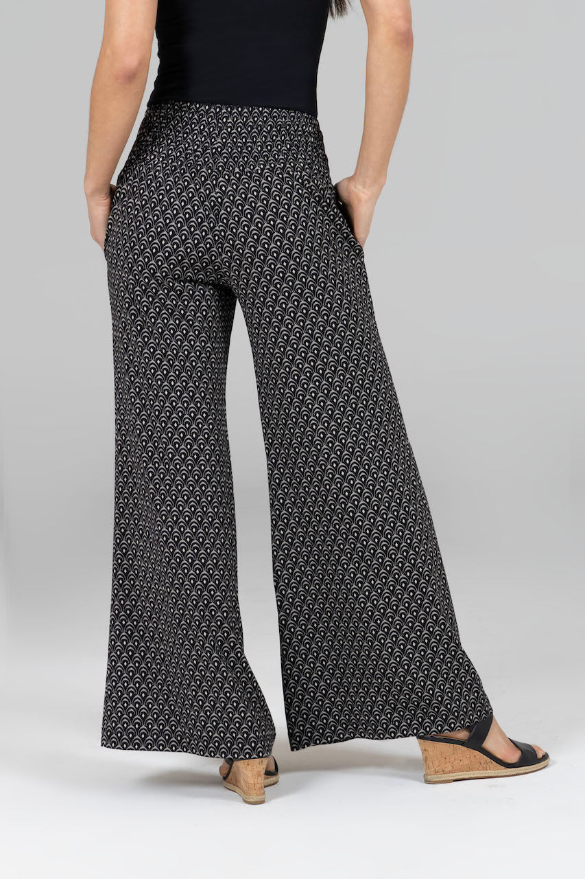 Person wearing black and white patterned wide-leg pants on a light gray background