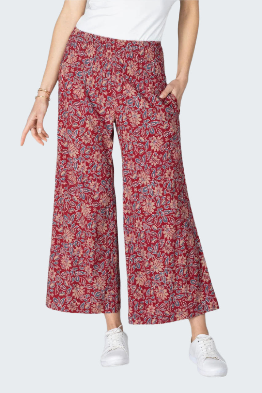 Person wearing red floral-patterned pants on a gray background