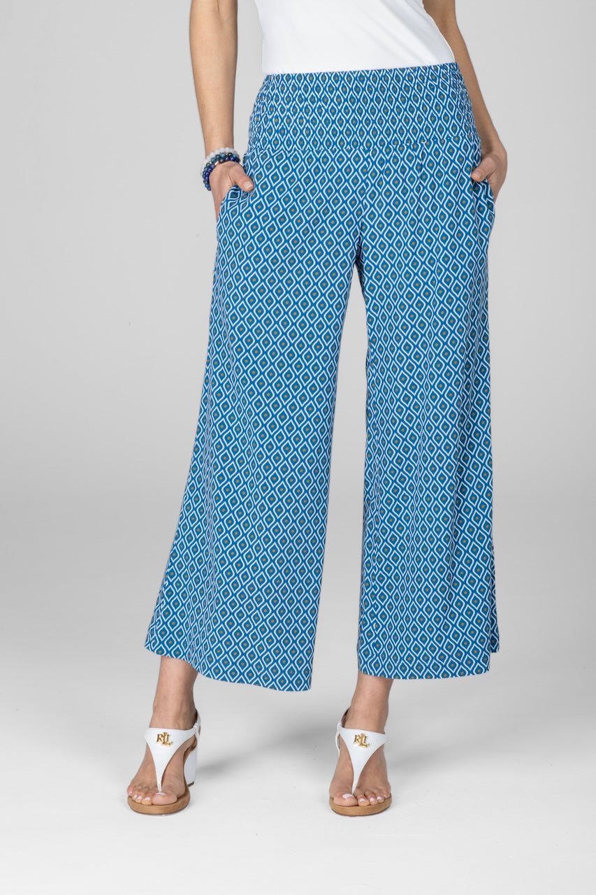 Person wearing blue patterned pants on a gray background