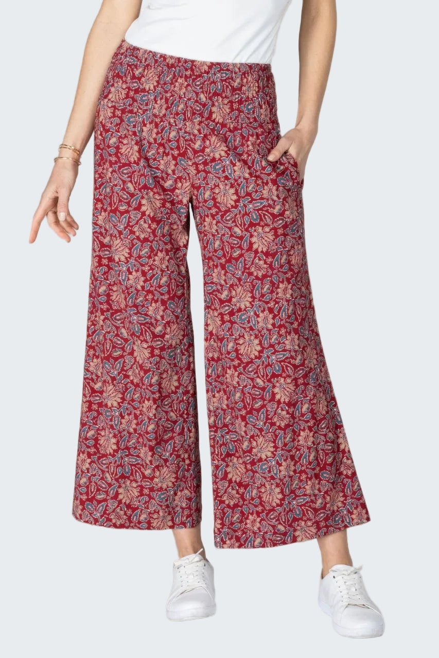 Person wearing red floral pants on a beige background