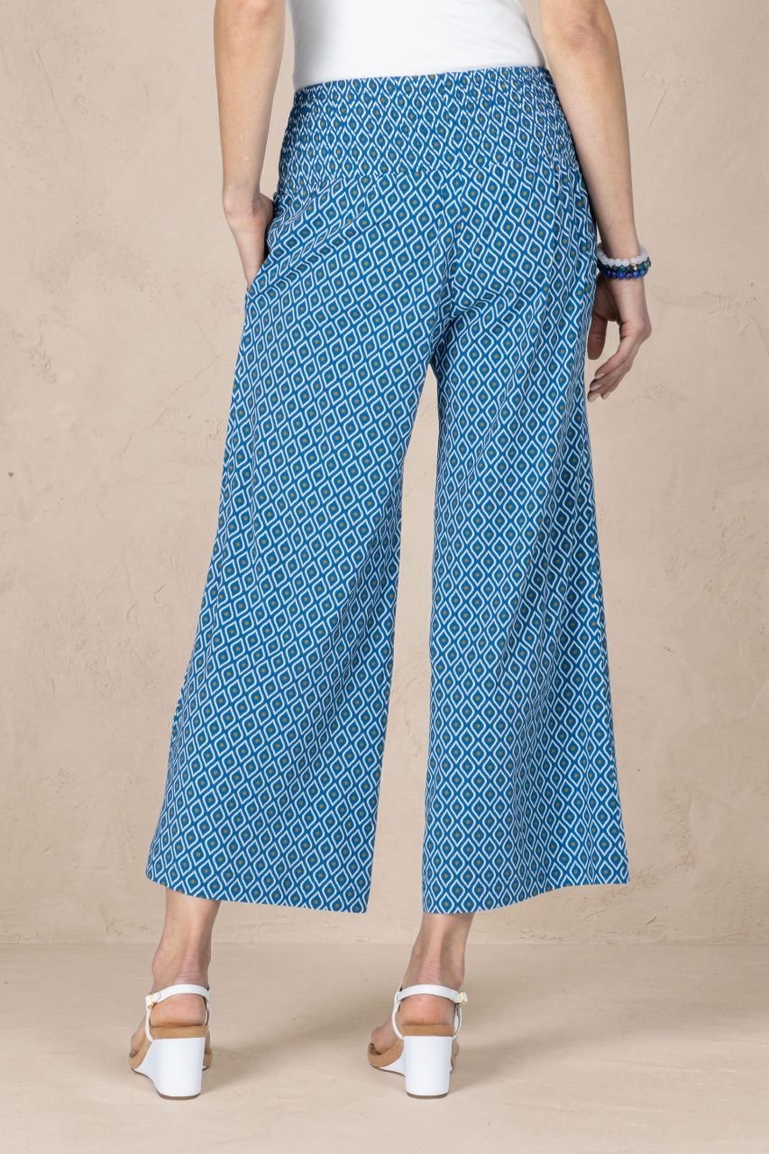 Person wearing blue patterned pants on a beige background