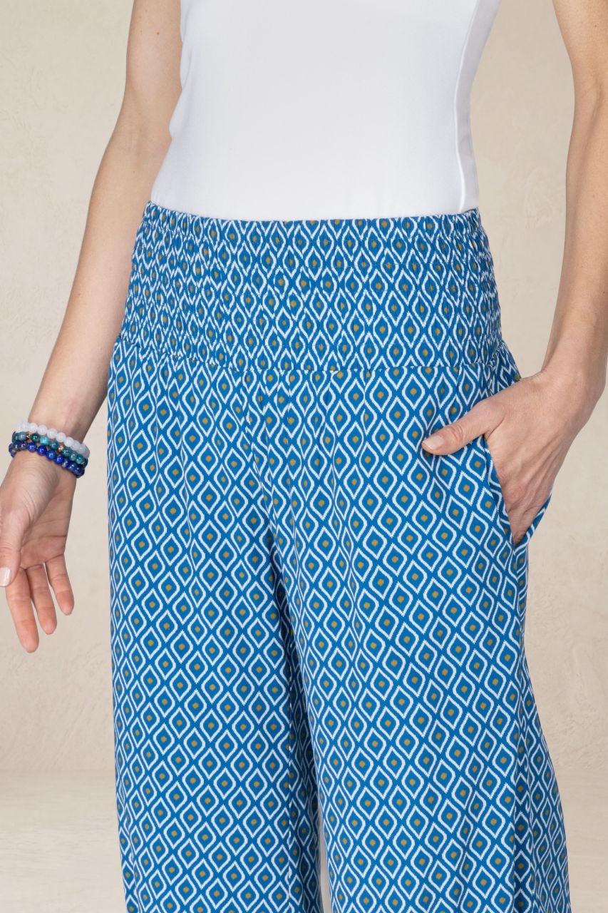 Person wearing blue patterned pants with a beige background