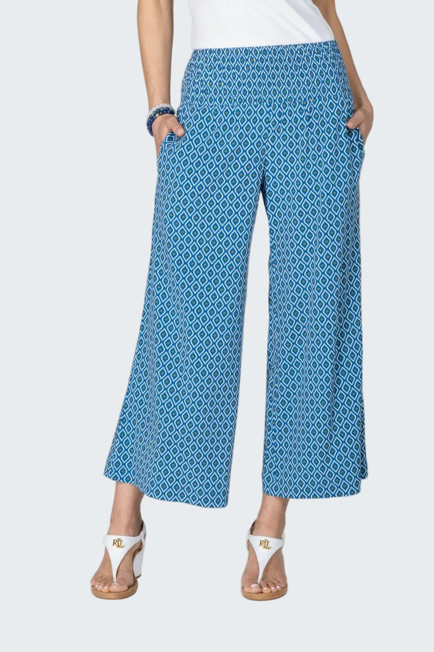 Person wearing blue patterned pants on a beige background