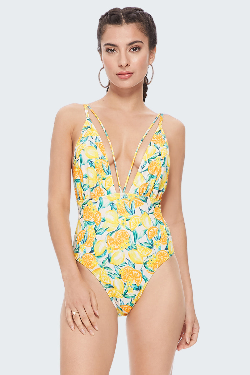 Woman wearing a yellow floral one-piece swimsuit on a white background