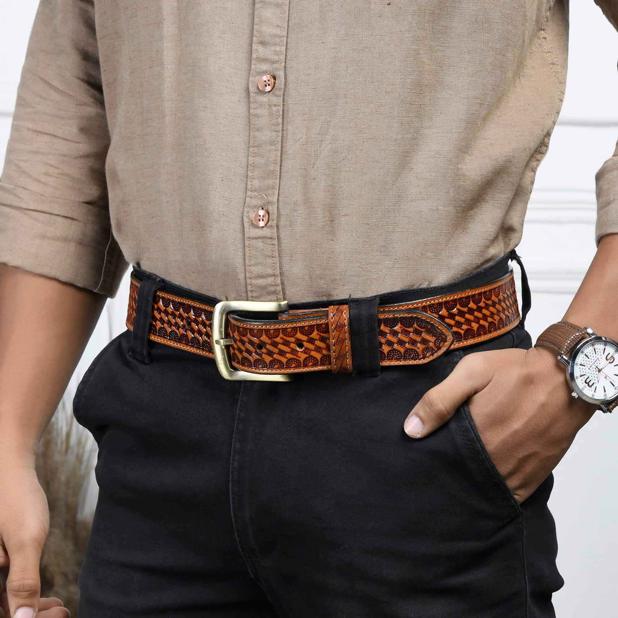Person wearing a brown leather belt and watch, with a neutral background