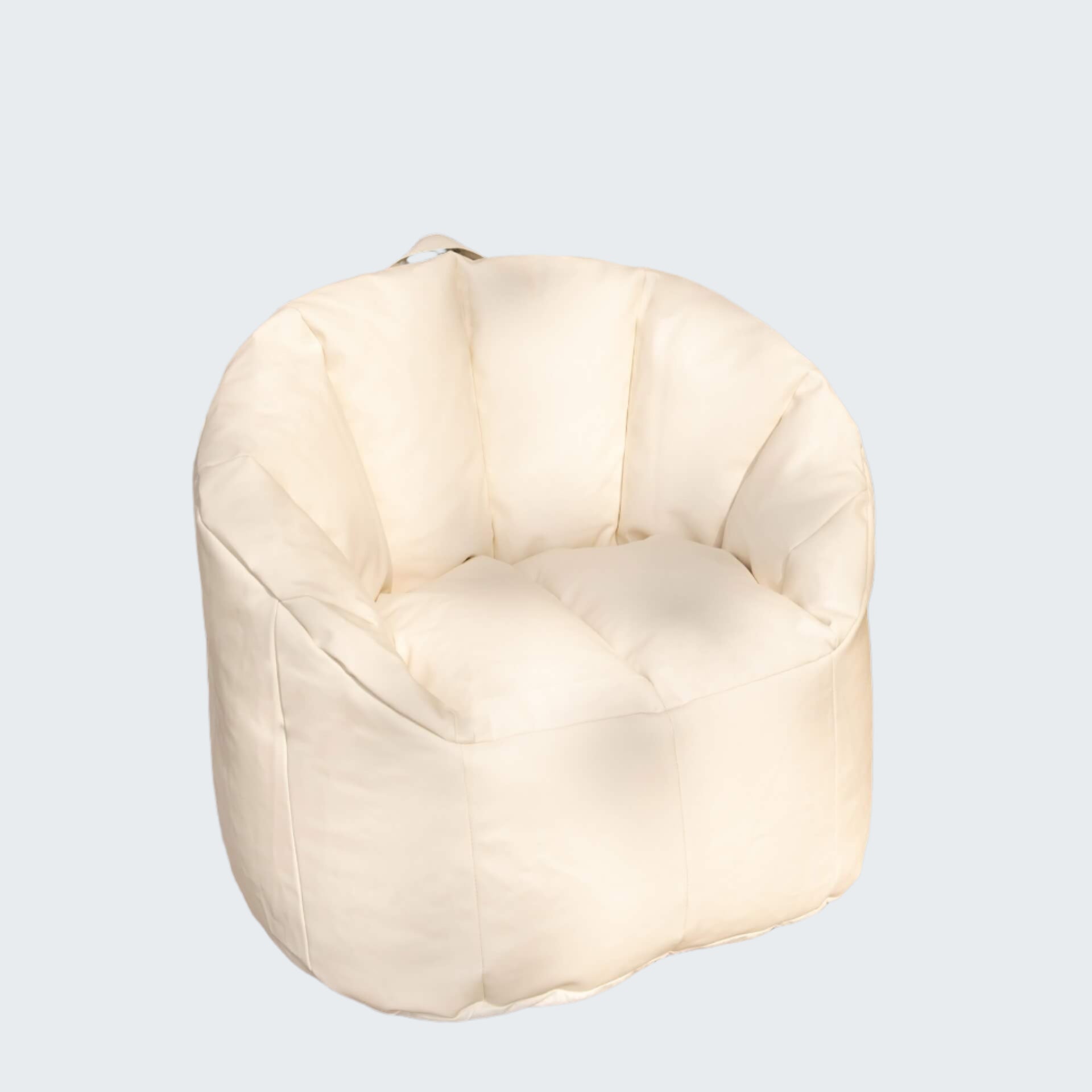 White bean bag chair on a wooden floor with a stone wall background