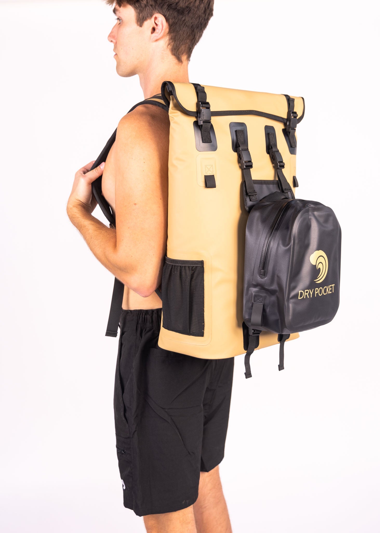 Person wearing a beige backpack with a black dry pocket attachment on a white background