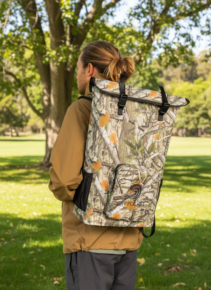 Person wearing a camouflage backpack with 'Dry Pak' branding on a white background