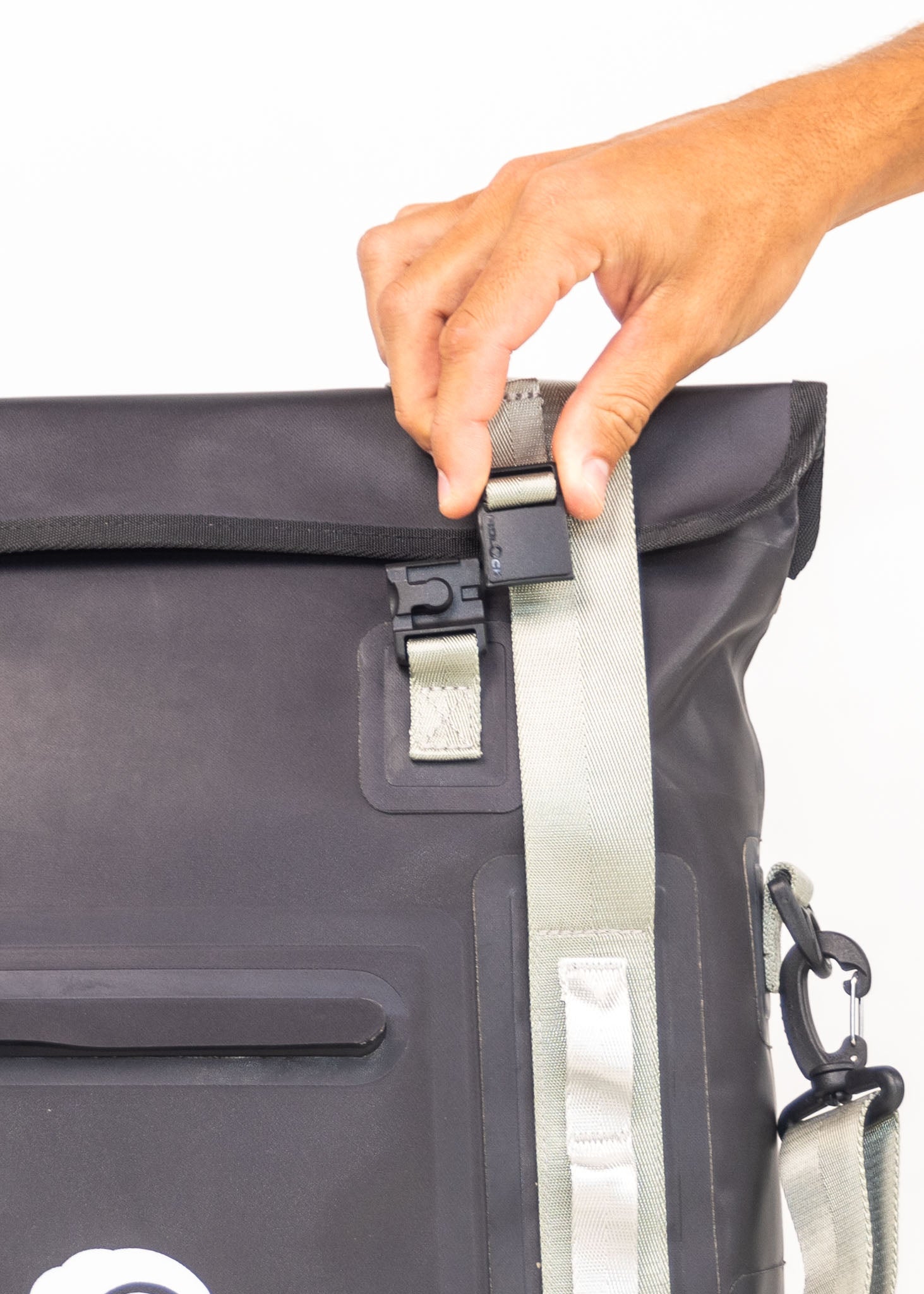Person opening a black backpack with a white background